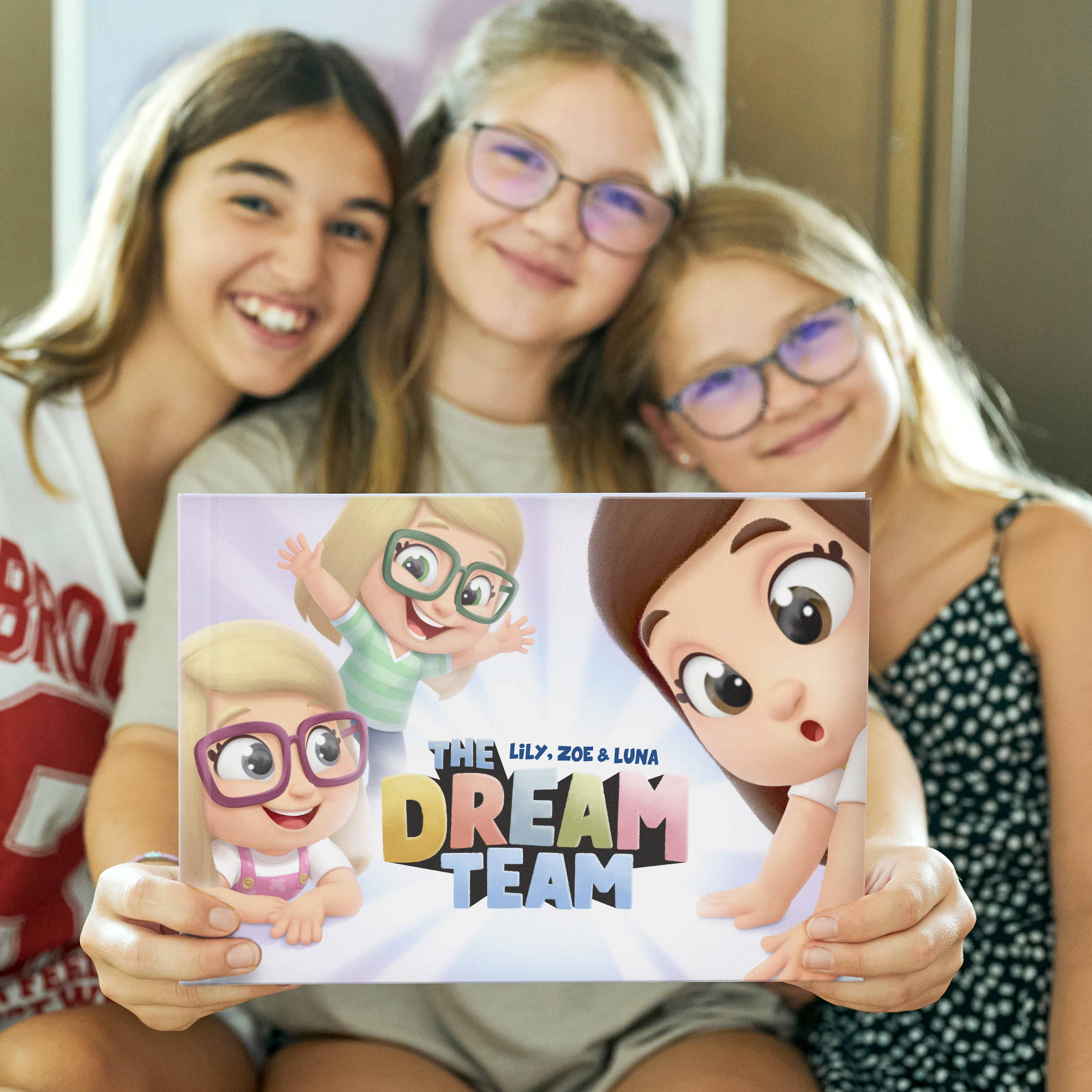 Three little girls having fun while reading the "Dream Team" book by Hooray Heroes.