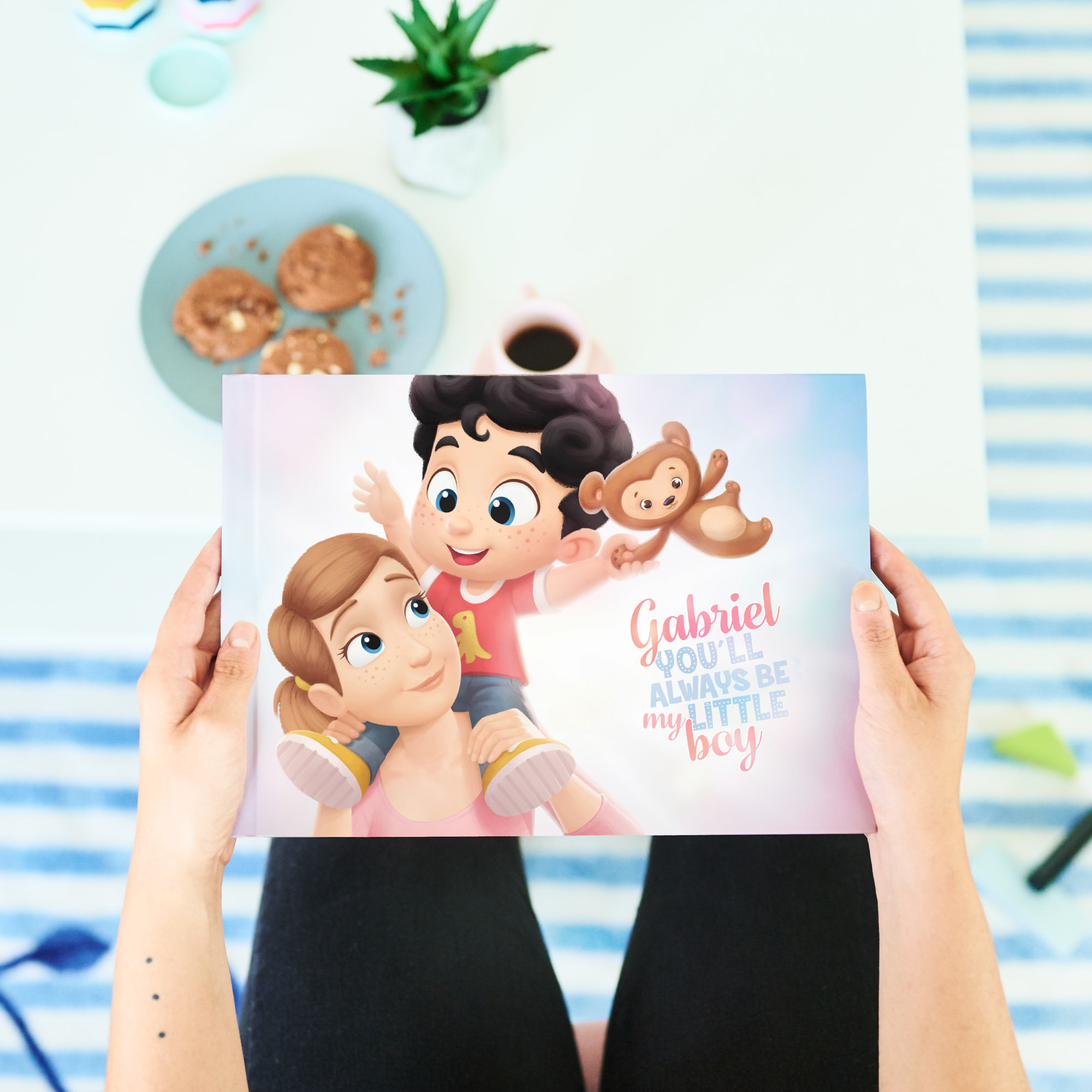 A woman holding "Gabriel You'll Always be My Little Boy" personalized book for mom and her kid